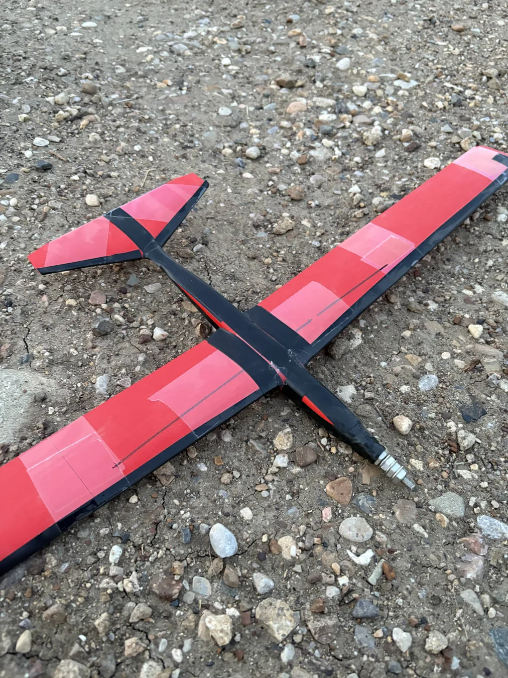 Red and black early RC airplane prototype outdoors