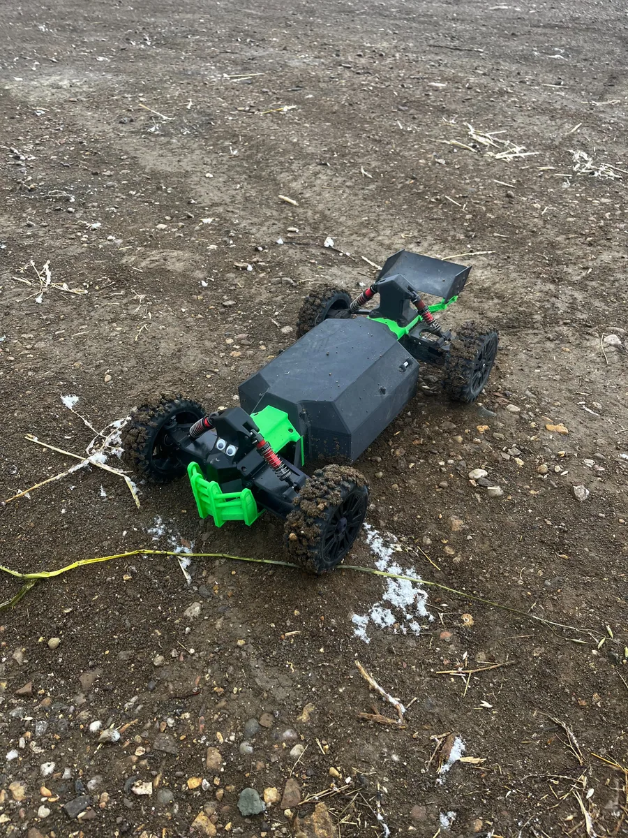 Custom blue and black RC car on a dirt surface